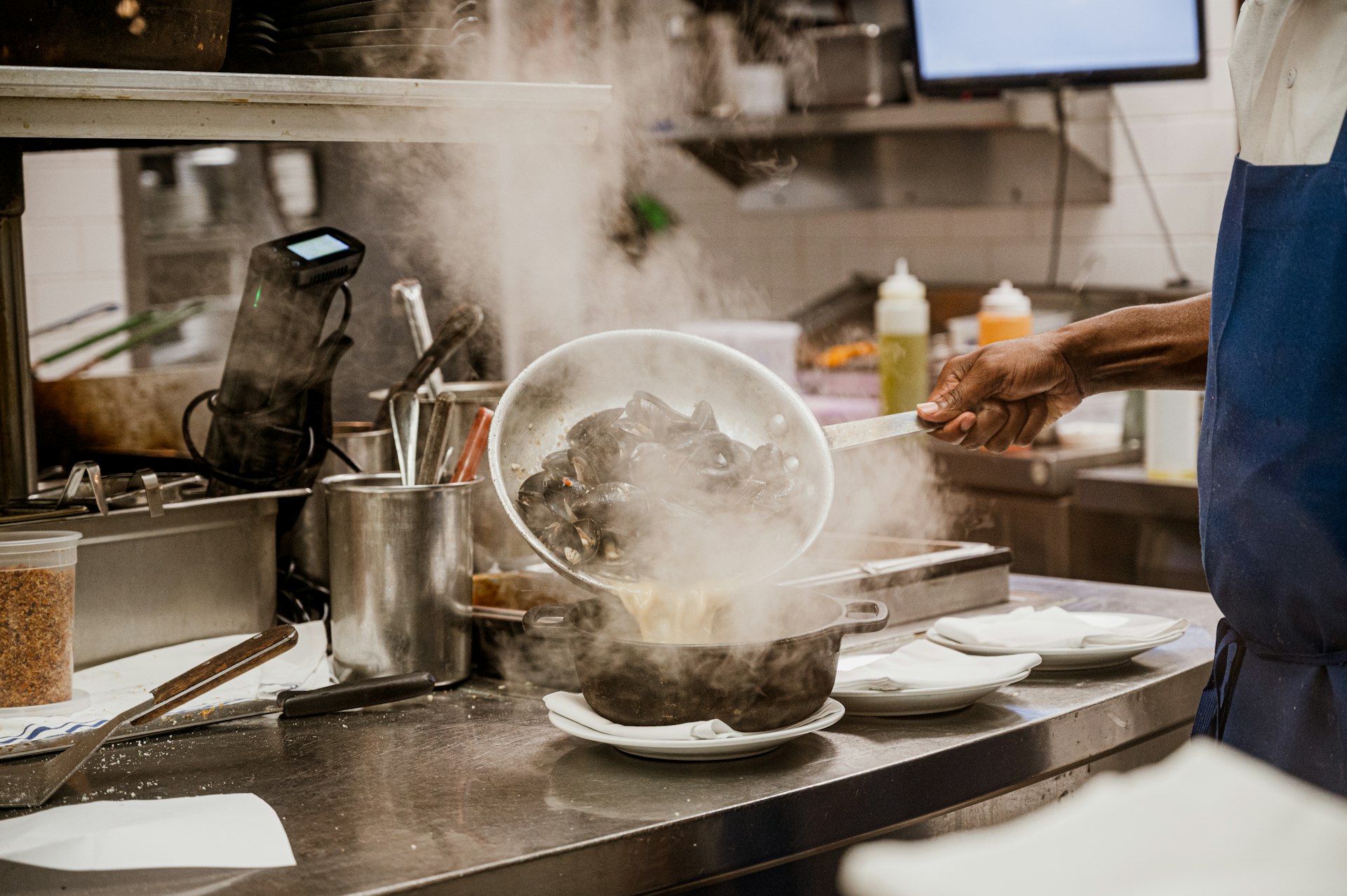 a person in a kitchen cooking food on a stove